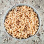 White beans in a bowl with a spoon.