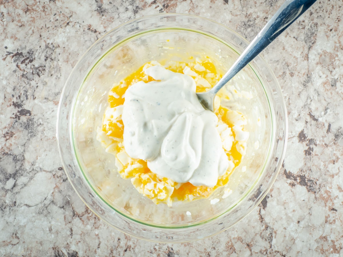 Mashed eggs in a bowl with yogurt.
