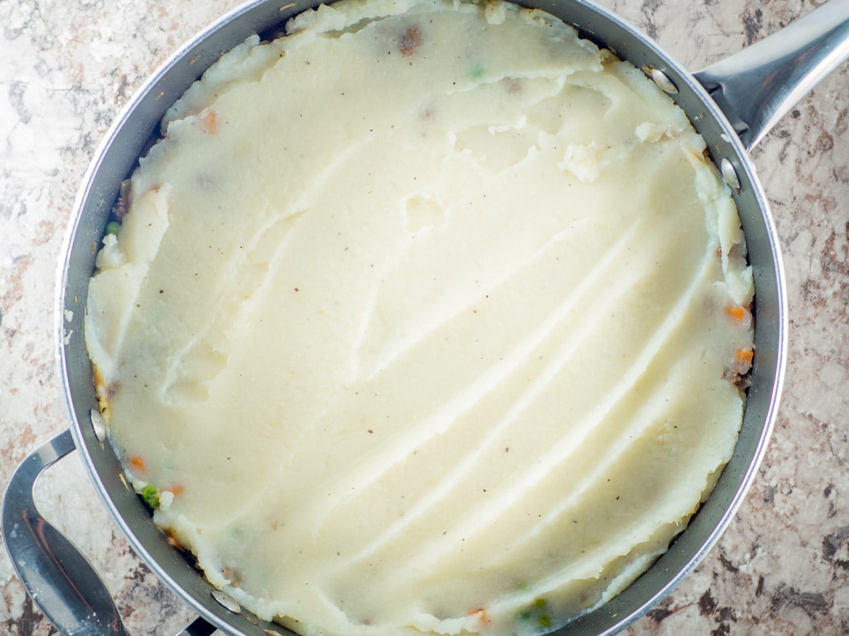 Potatoes spread over filling.