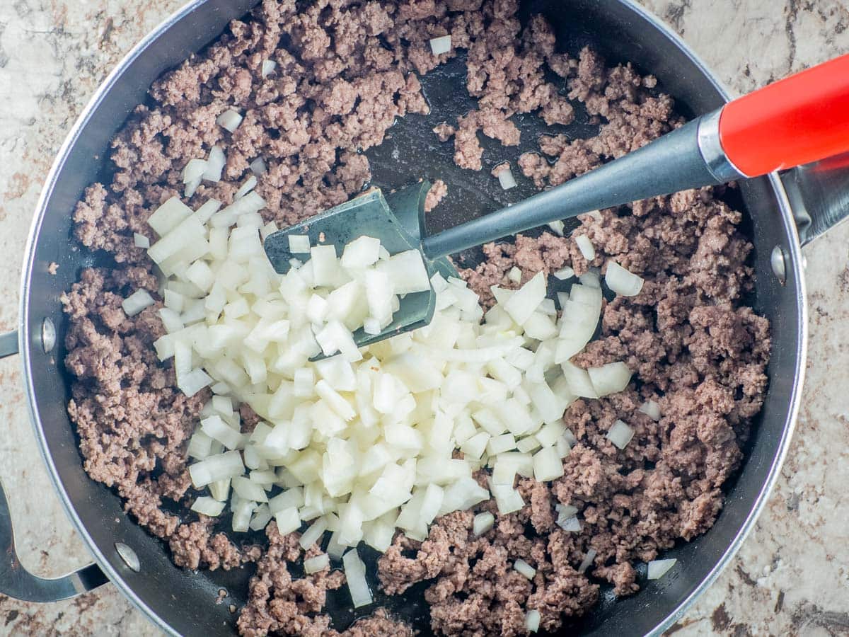 Ground beef browned in a skillet with onions.