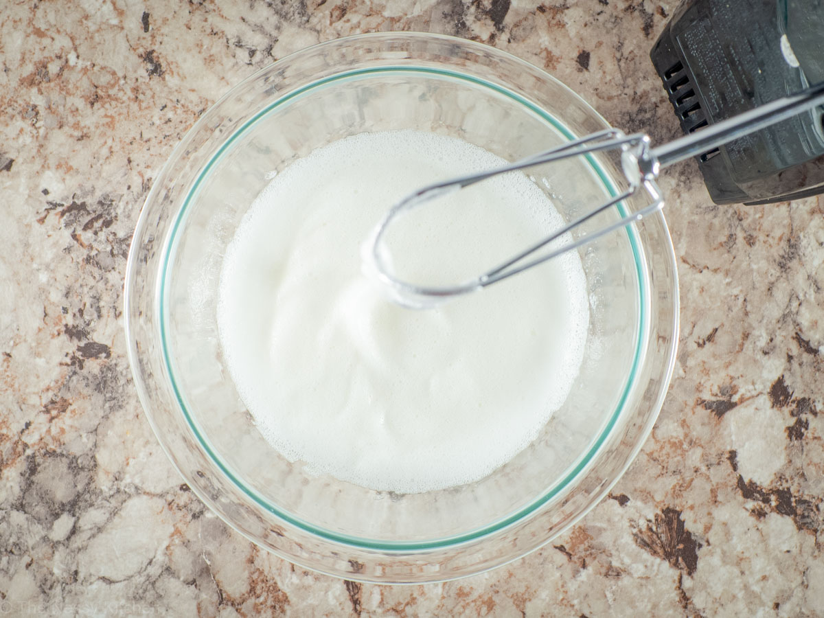 Egg whites whipped in a bowl.