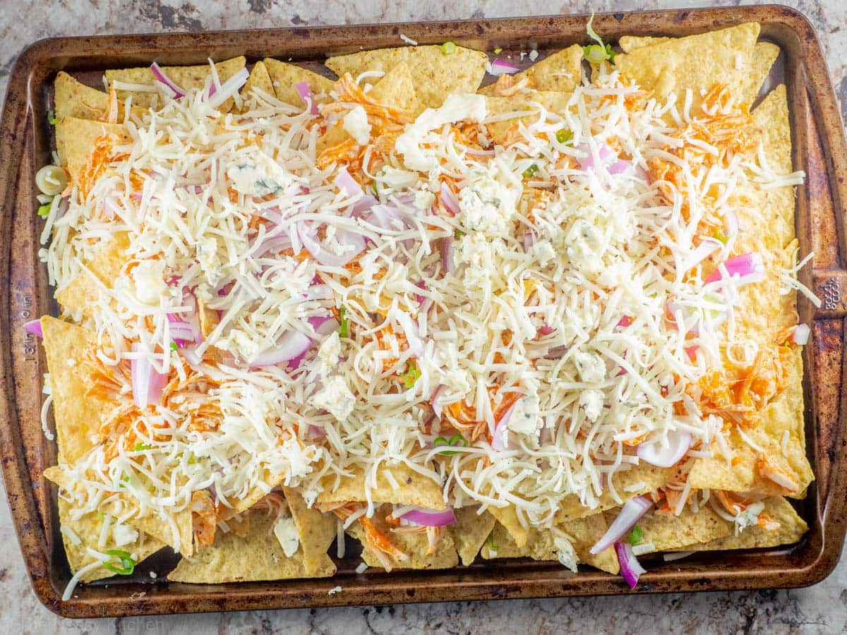 Second layer of buffalo chicken nachos assembled on a sheet pan.