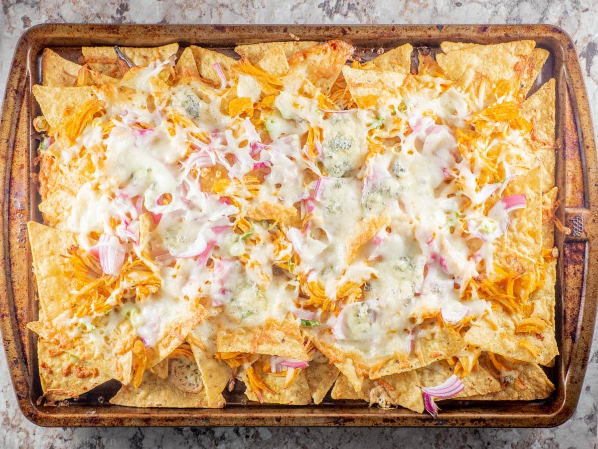 Baked pan of nachos with melted cheese.