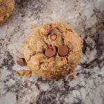 Cooke on a count topped with chocolate chips and surrounded by cookie crumbs.