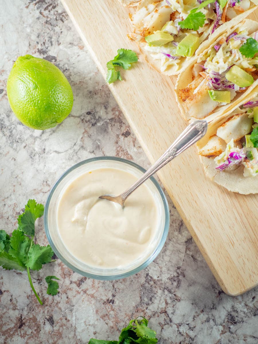 Fish taco sauce in a bowl with a spoon.