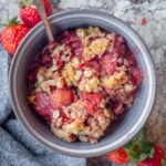Strawberry crisp with oatmeal topping in a bowl.