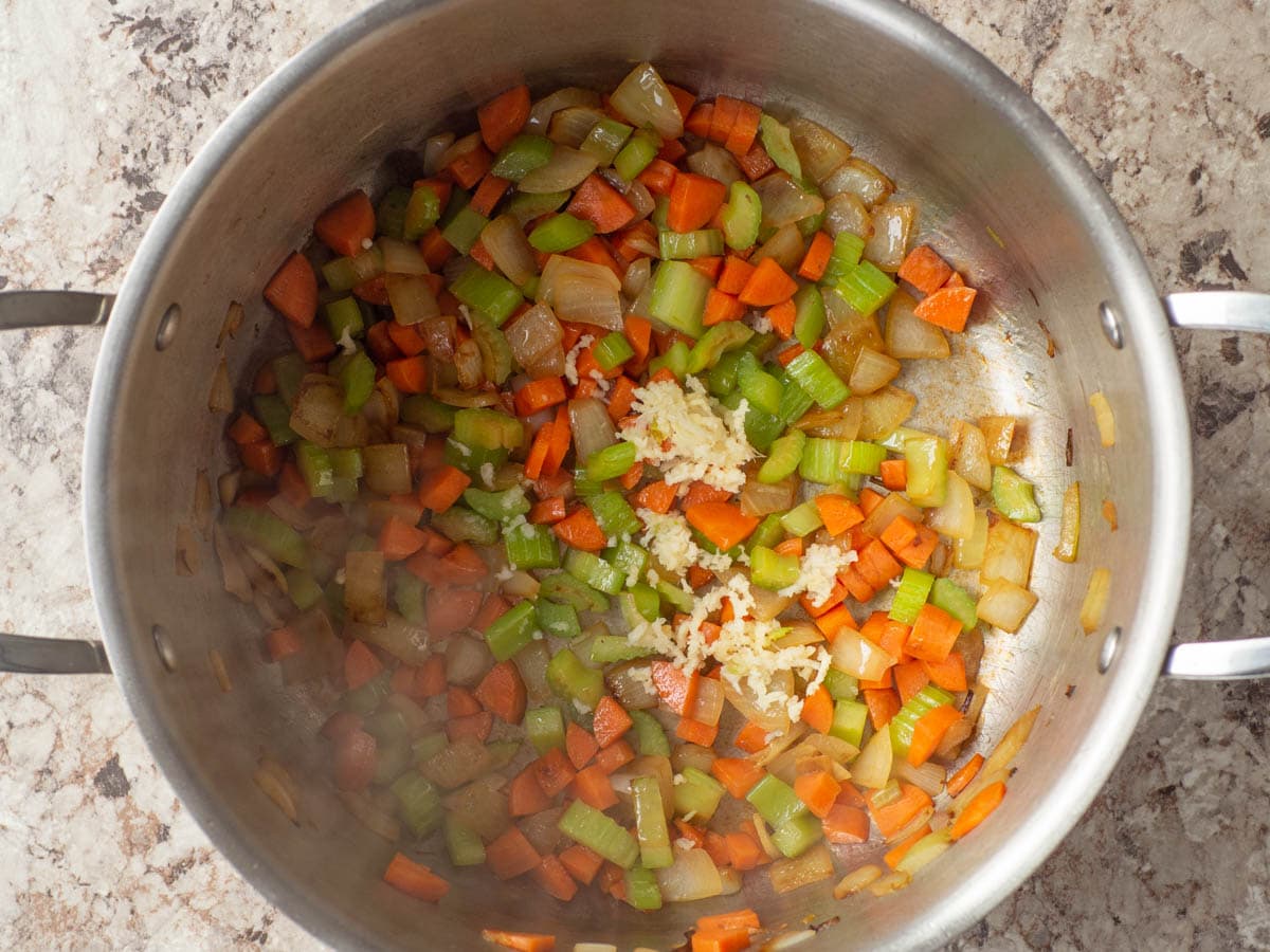 Garlic stirred into a pot of vegetables.