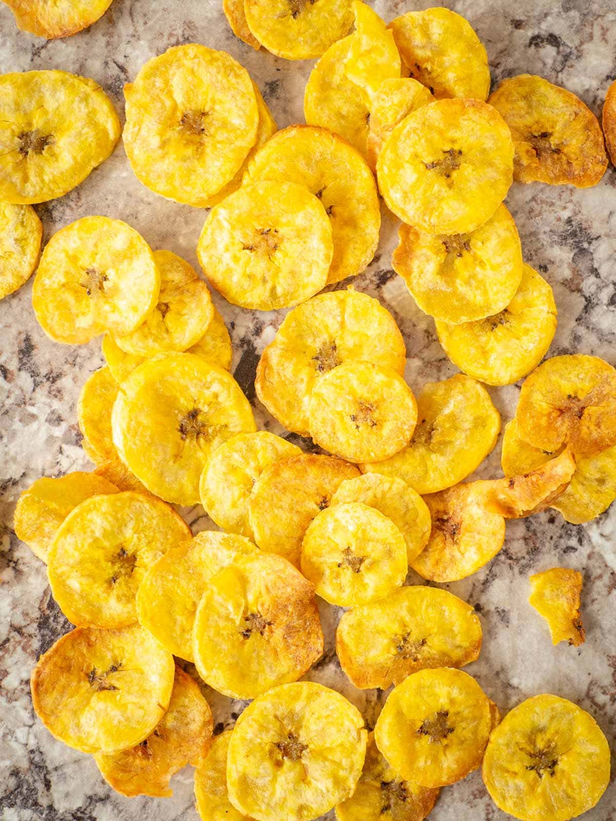 Plantain chips spread out onto a countertop.