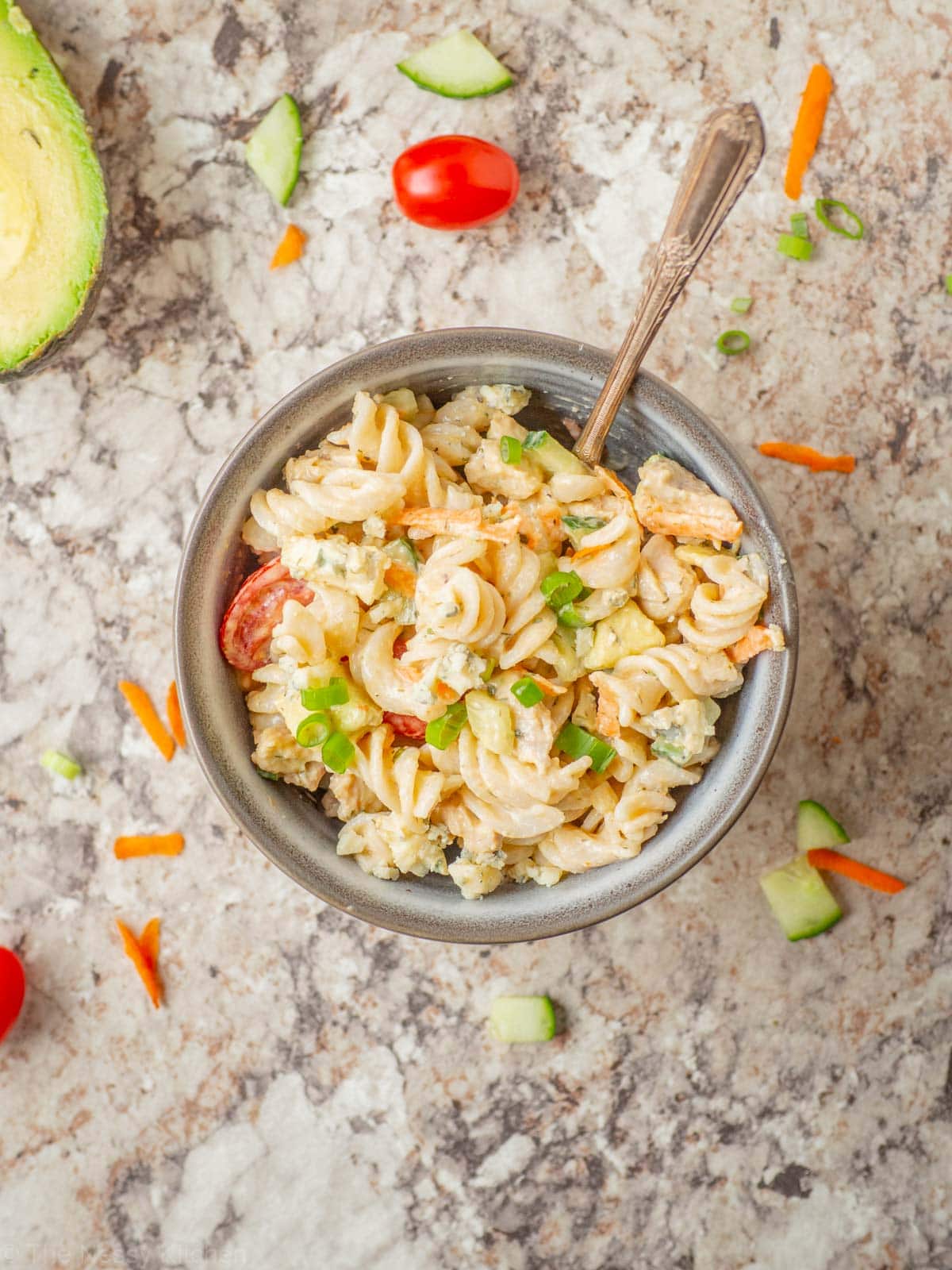 Buffalo pasta salad in a bowl with a spoon.