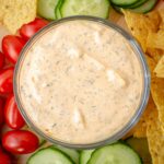 Buffalo ranch dip in a bowl surrounded by vegetables.