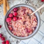 Oatmeal in a bowl topped with cranberries.