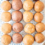 Four different variations of date protein balls on a plate.