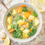 Vegetable soup in a bowl with a spoon.