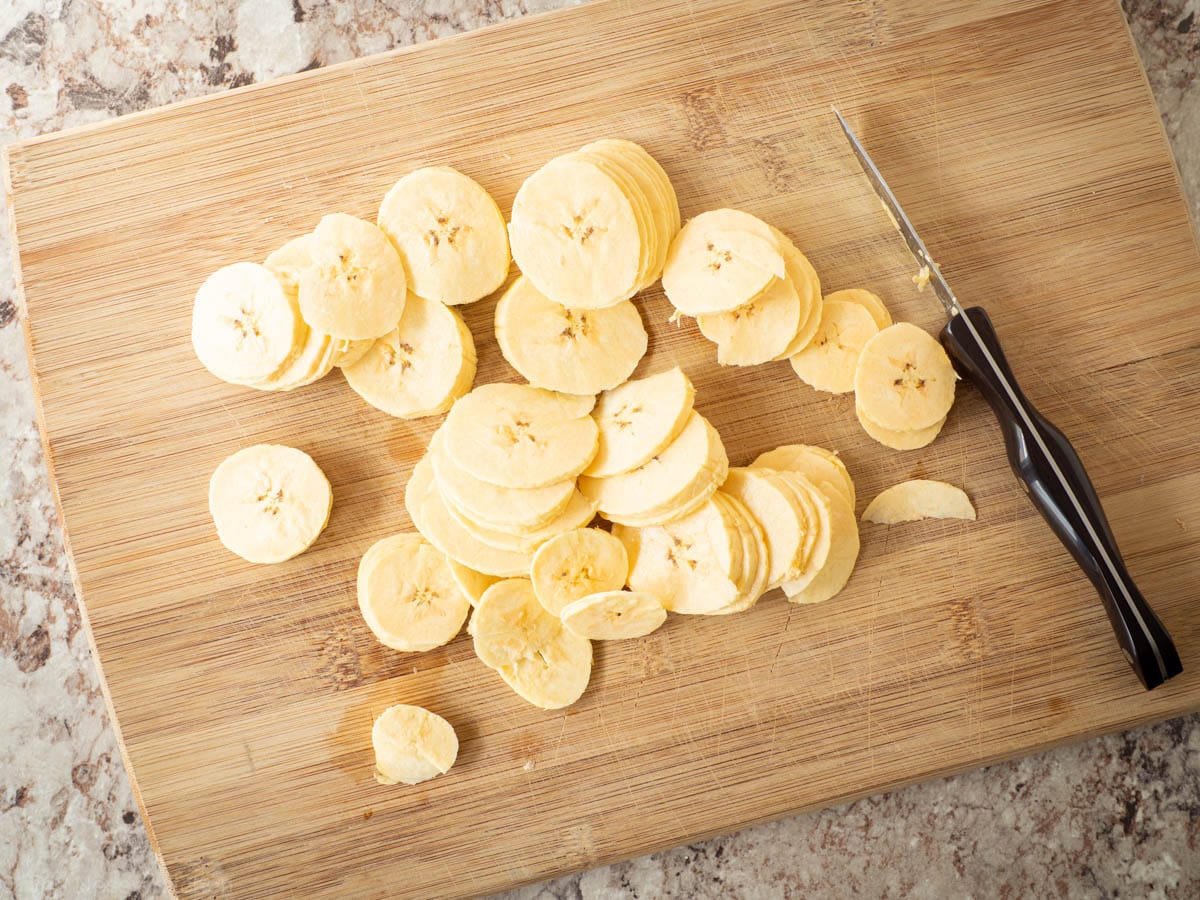 Green plantain sliced on a cutting board.