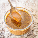 Black pepper stir fry sauce in a bowl with a spoon.