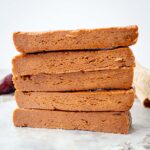 Date protein bars sliced and stacked on top of one another.
