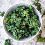 Crispy kale chips with garlic in a bowl.
