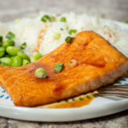 Teriyaki baked salmon on a plate with rice.
