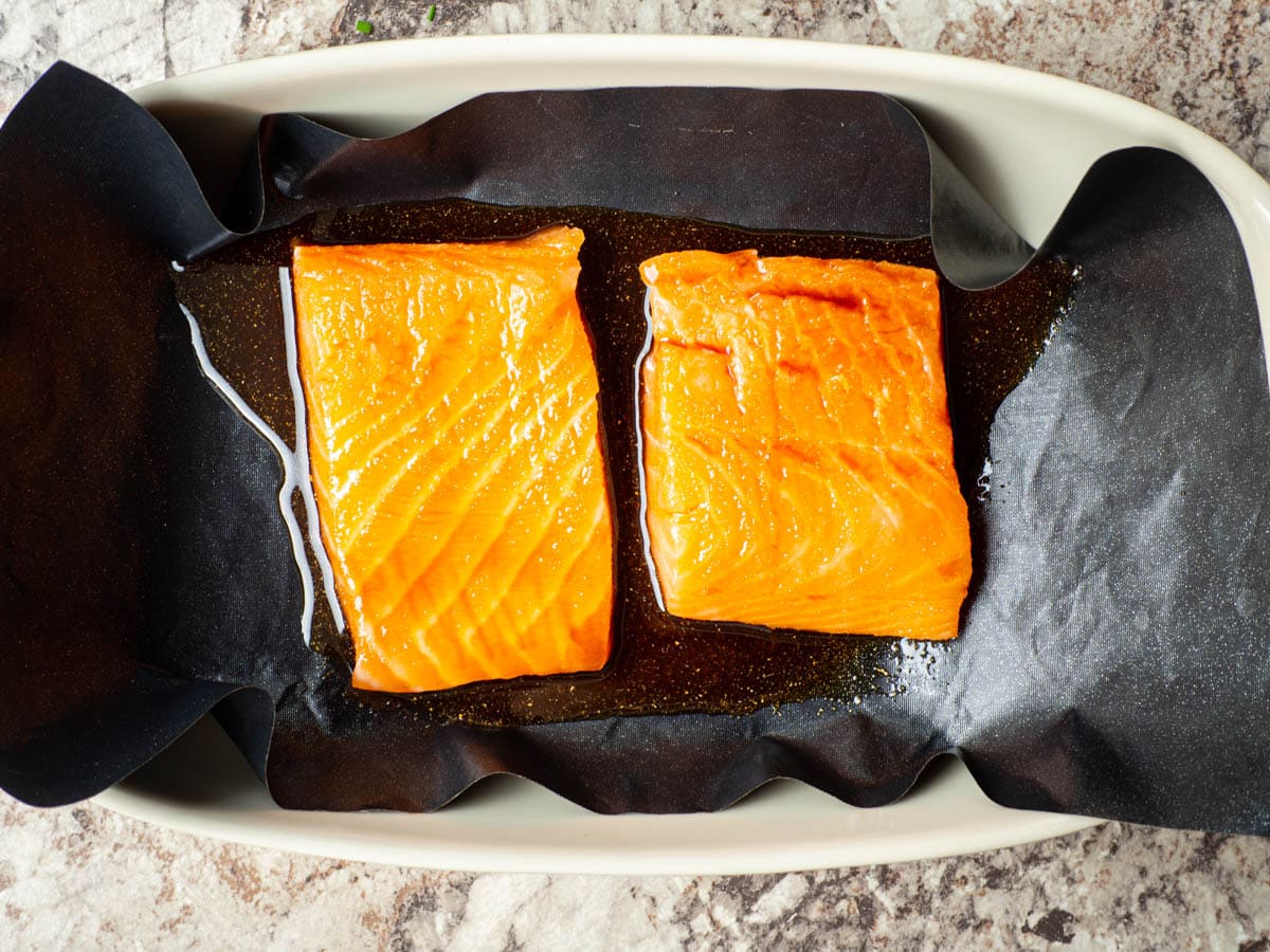 Raw salmon in a lined baking dish.