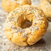 Oat flour bagel on a countertop topped with everything bagel seasoning.