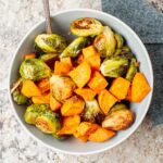Sweet potato cubes and Brussels sprouts in a bowl.
