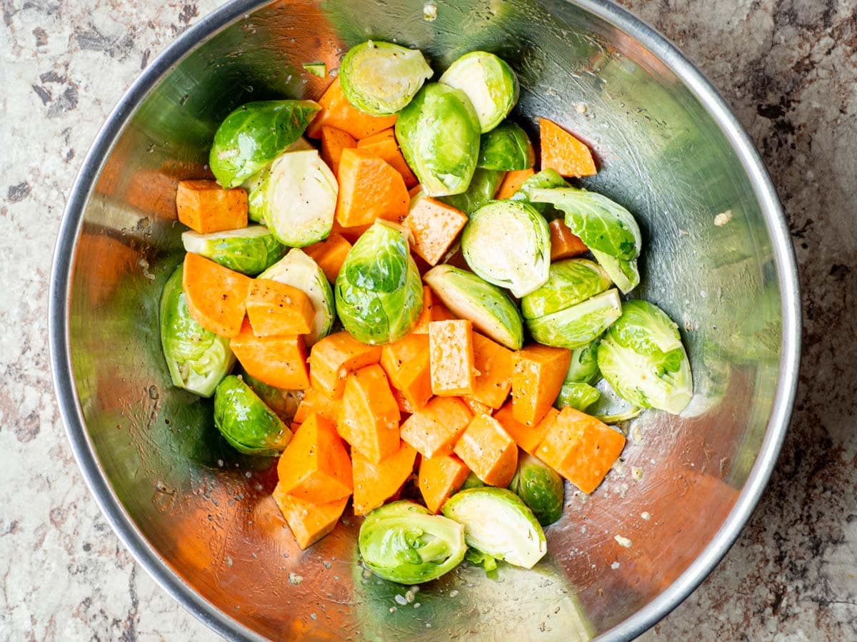 Sweet potatoes and Brussels sprouts in a large mixing bowl.