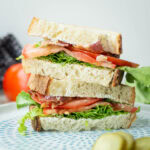 Sliced BLT sandwich on sourdough bread.