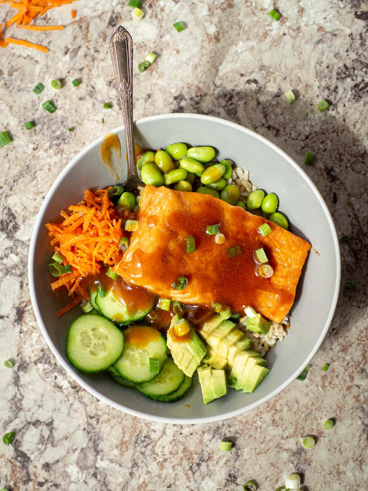 Teriyaki salmon in a bowl with rice and vegetables.