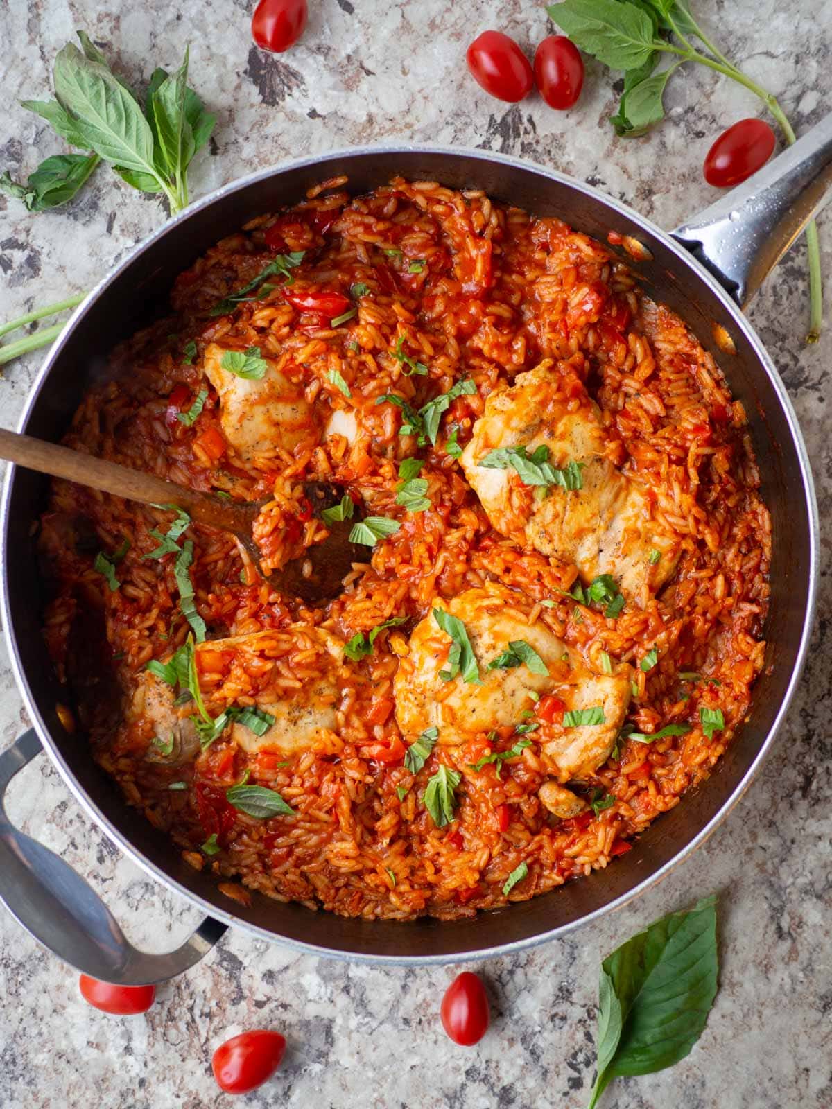 Tomato basil rice and chicken in a skillet.