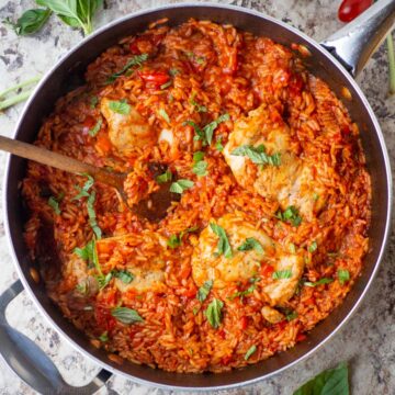 Tomato basil rice and chicken in a skillet.