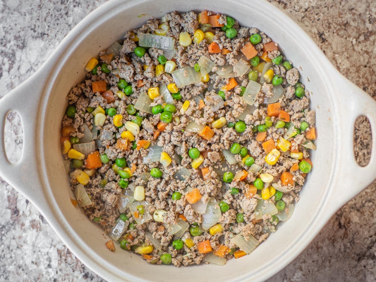 Ground turkey filling in the base of a casserole dish.