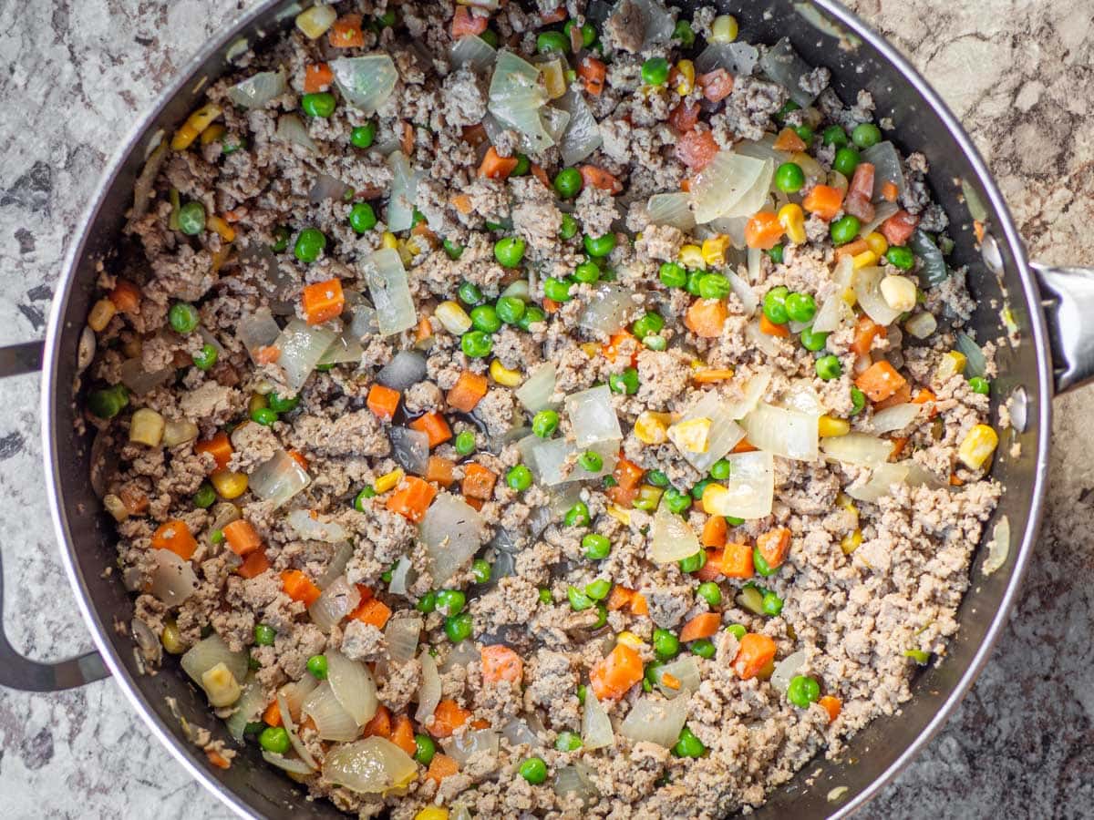 Meat filling cooking in a skillet.