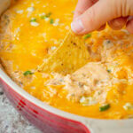 Chip being dipped into Buffalo chicken dip.