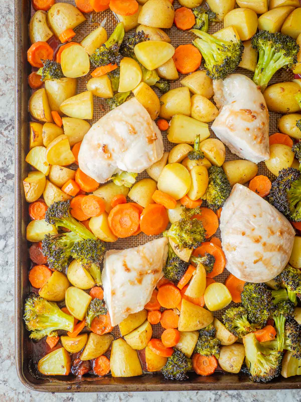 Vegetables and chicken on a sheet pan.