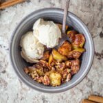 Air fried apples in a bowl topped with ice cream.