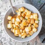 Air fryer diced potatoes in a bowl.
