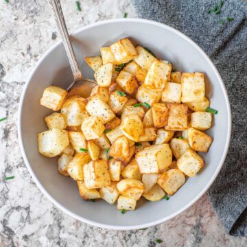 Air fryer diced potatoes in a bowl.