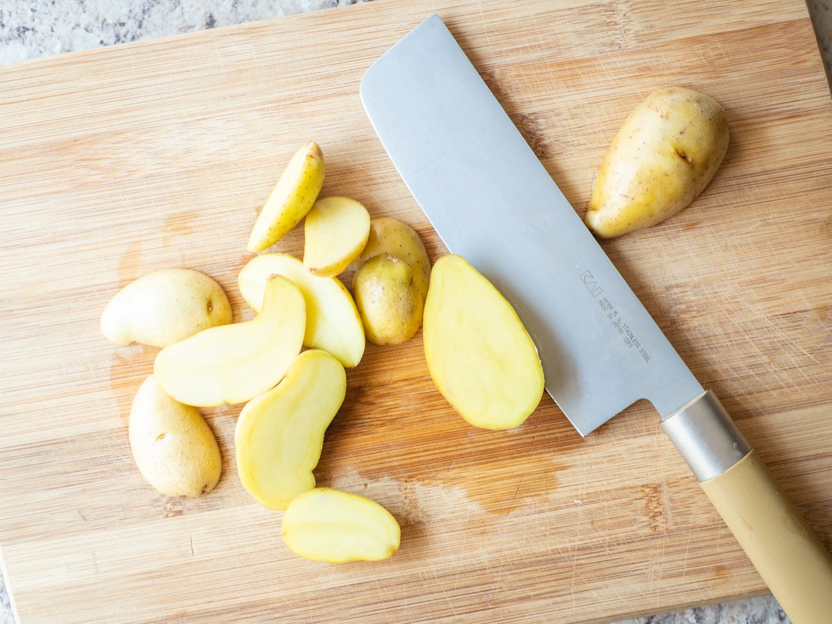 Fingerling potatoes sliced on a cutting board.