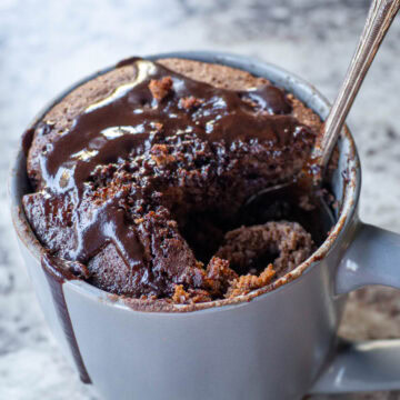 Spoon dipping into a mug of oat cake.