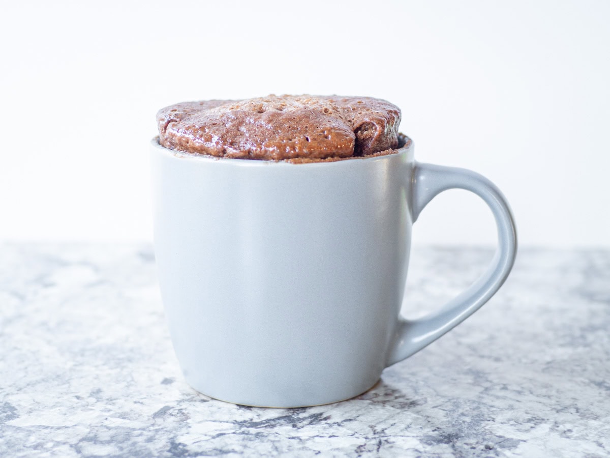 Cooked chocolate mug cake resting on a countertop.