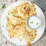 Potato fritters on a plate with dip.