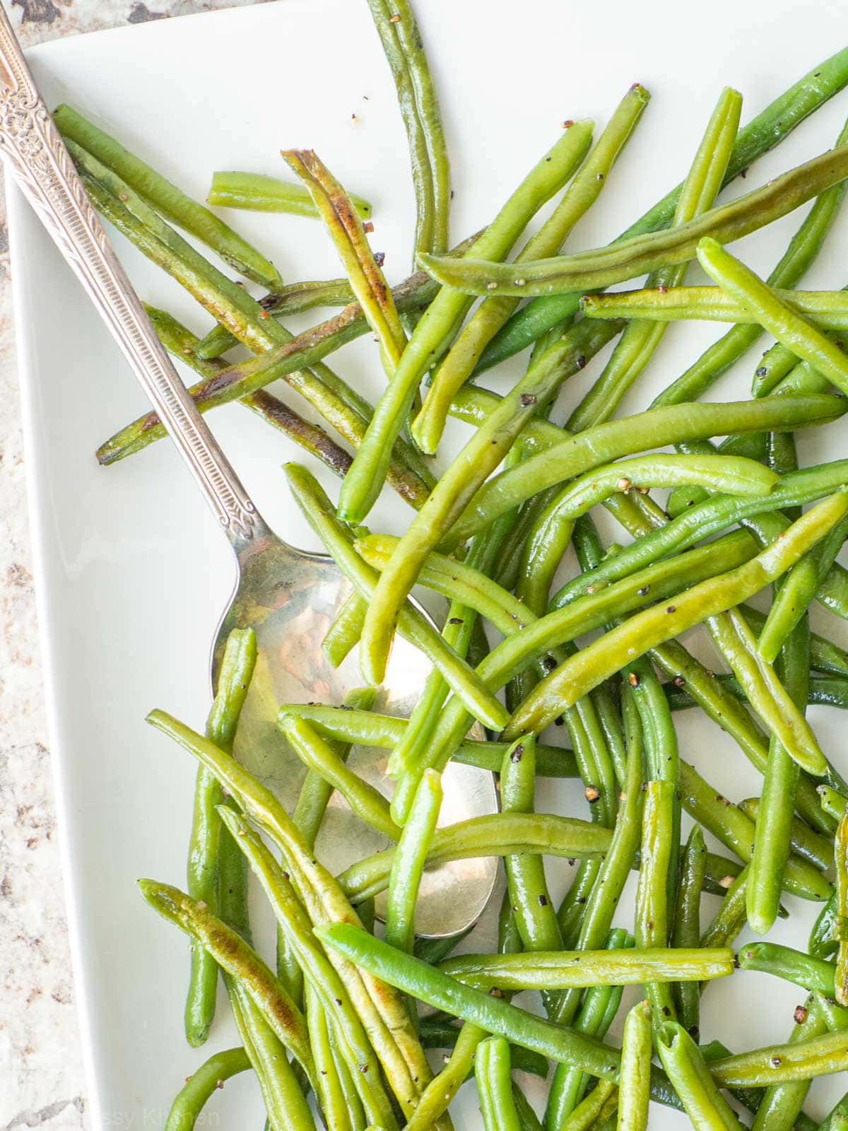 Green beans on a plate with a spoon.