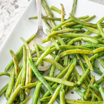Green beans on a plate with a spoon.