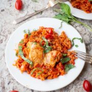 Tomato basil chicken and rice on a plate.
