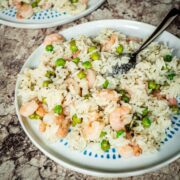Rice and shrimp on a plate with green peas.