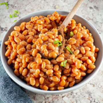 Baked beans in a bowl with a spoon.