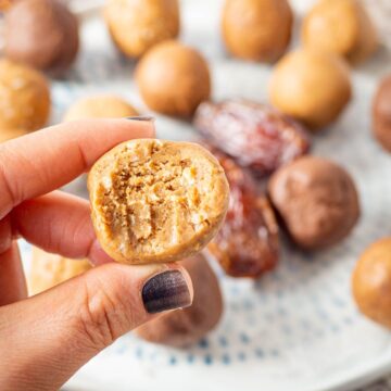 Hand holding a snack bar with a bite taken out.