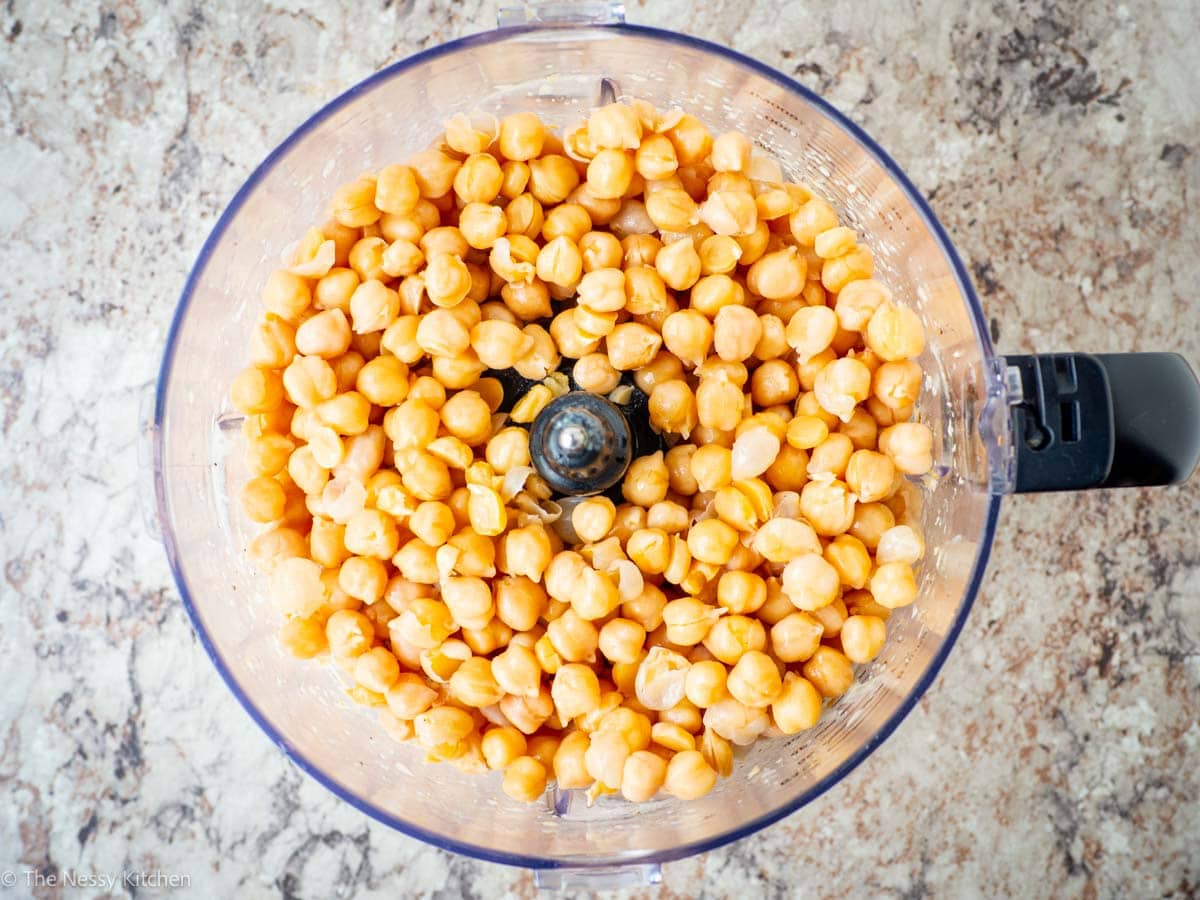 Chickpeas added to the base of a food processor.