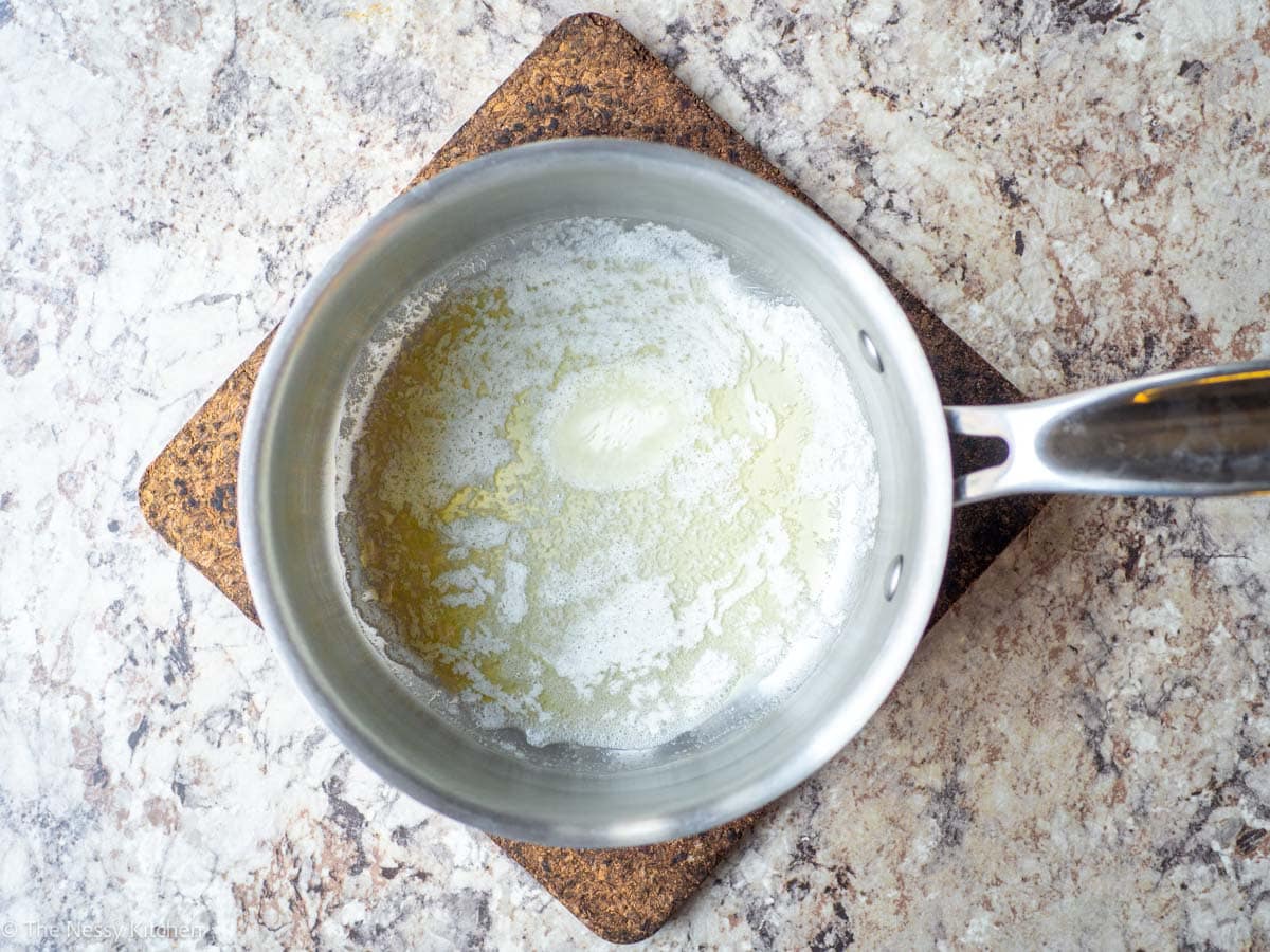 Butter melted in the bottom of a saucepan.