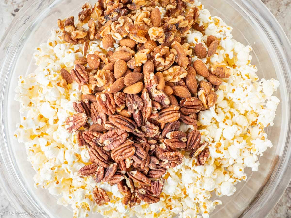 Popcorn and nuts poured into a large mixing bowl.